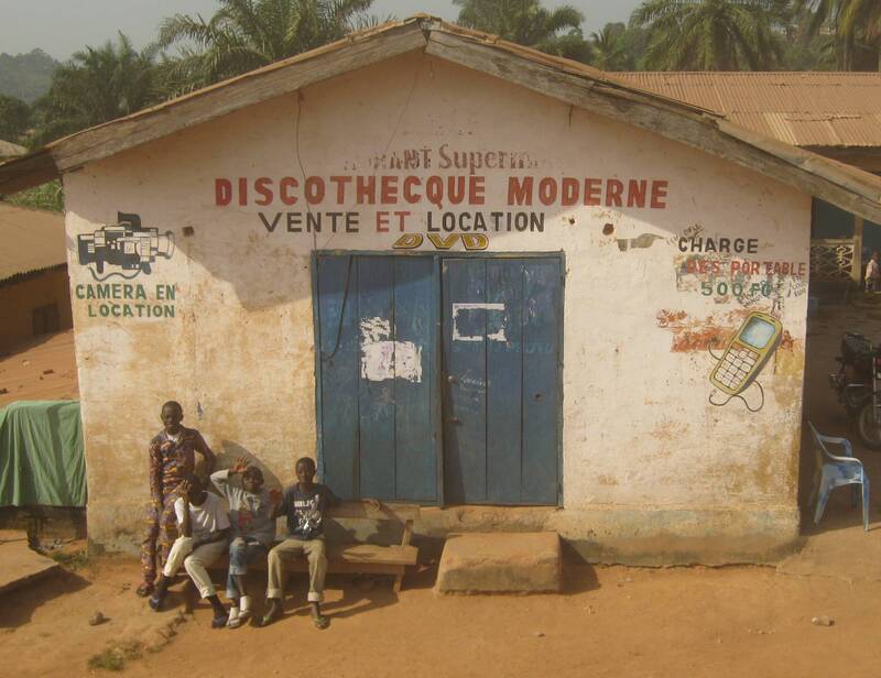Young men sitting outside the "discotheque moderne" (modern disco), Guinea