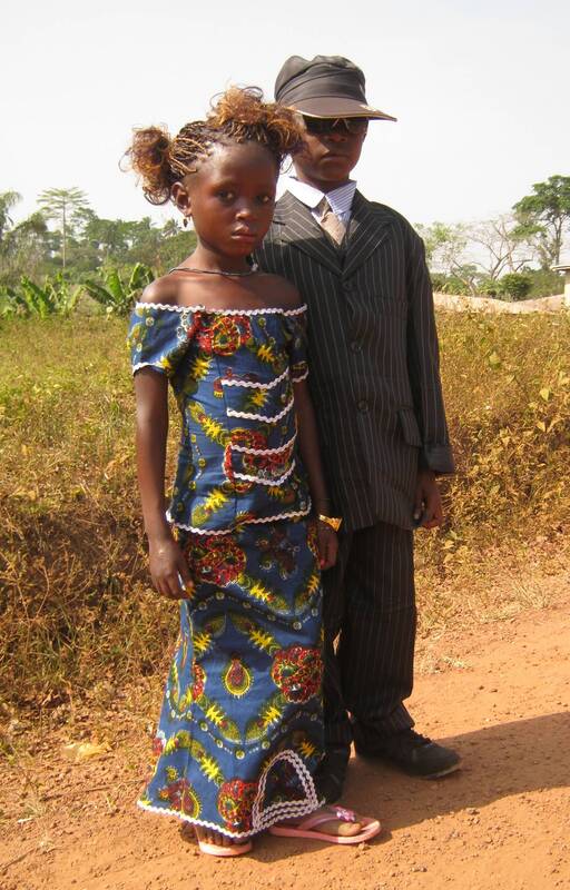 A somber young couple dressed in their new year's best in Bossou, Guinea