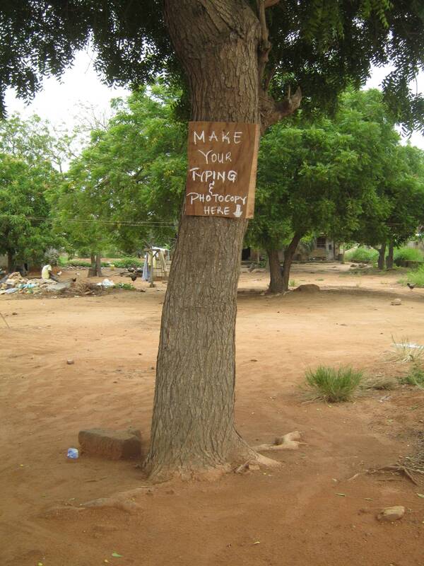 "Make your typing and photocopy here" sign on a tree with nothing around, Ghana